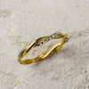 Gold bracelet with crystal accents on a textured beige background