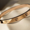 Gold bracelet with heart-shaped diamond accents on a soft fabric background