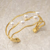 Gold bracelet with pearls on a beige background