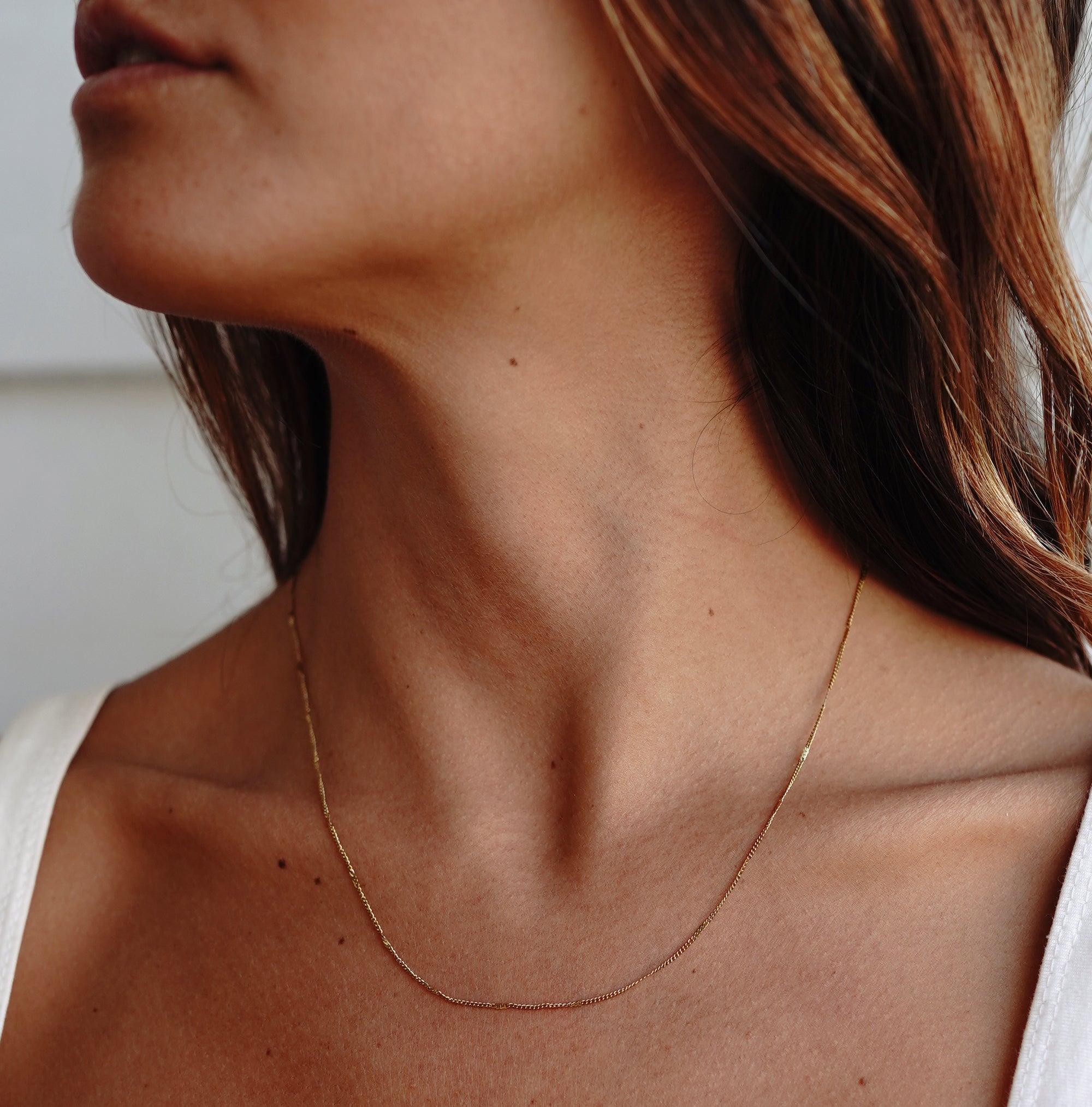 A model wearing a gold chain necklace