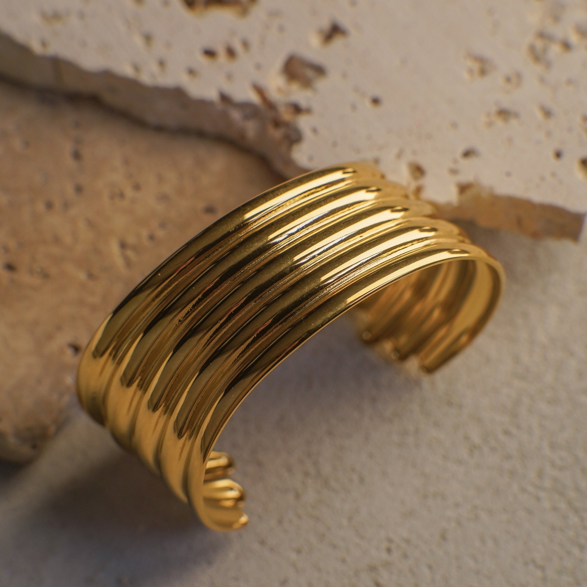 Gold bracelet on a textured stone surface