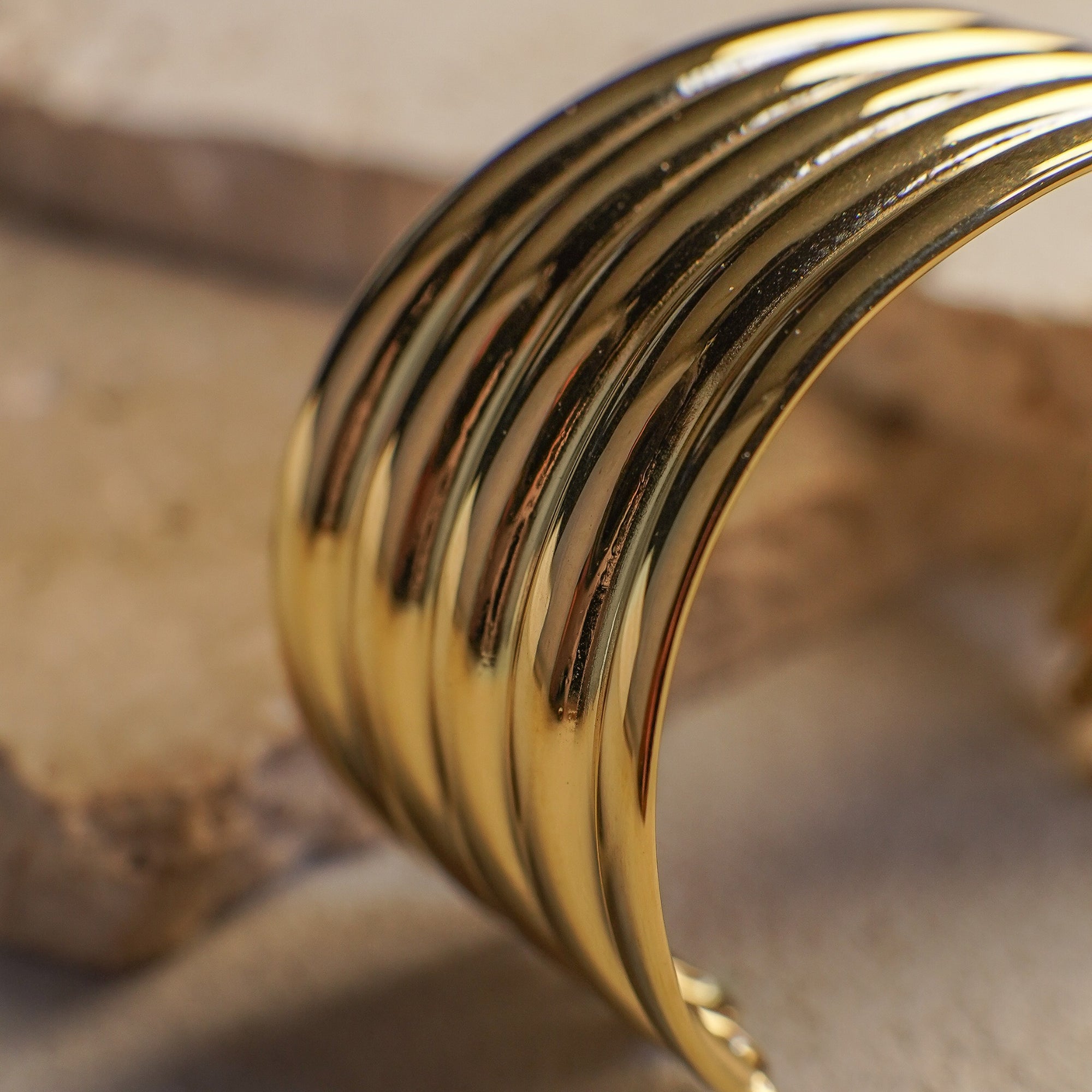 Close-up of a gold bracelet on a textured surface