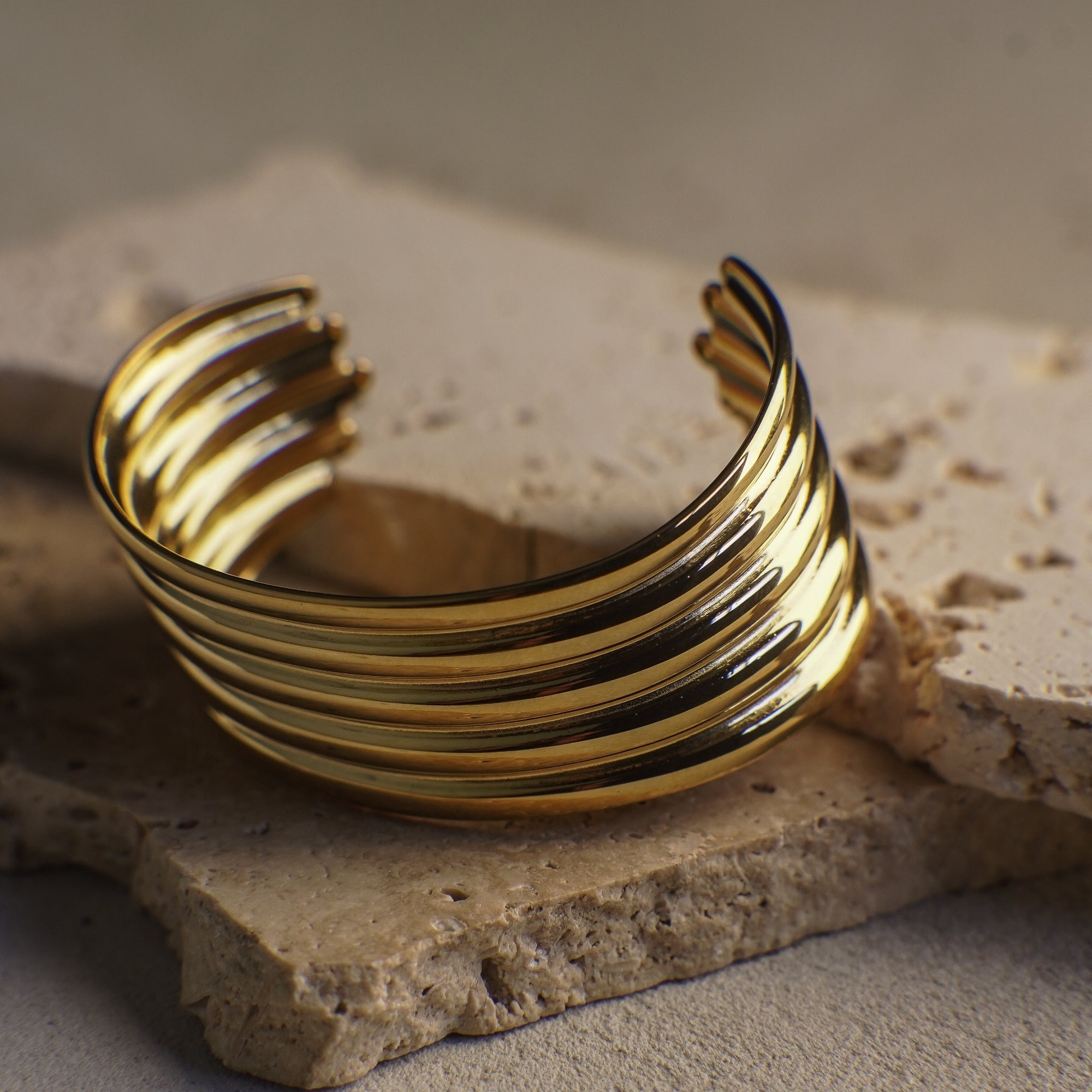 Gold bracelet on a textured stone surface