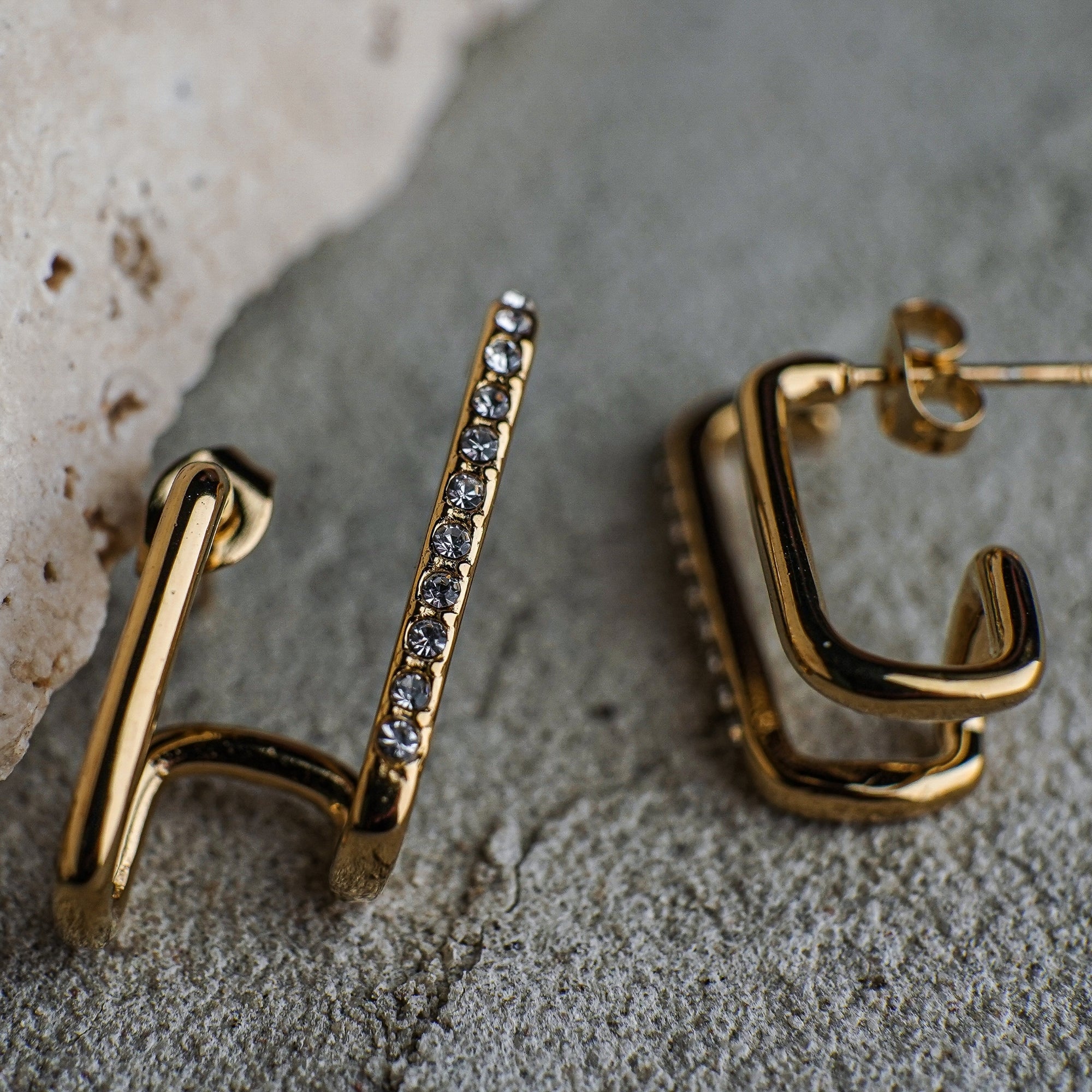 Gold hoop earrings on a textured surface
