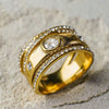 Gold ring with diamond accents on a textured surface
