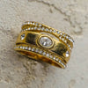 Gold ring with embedded diamonds on a textured surface