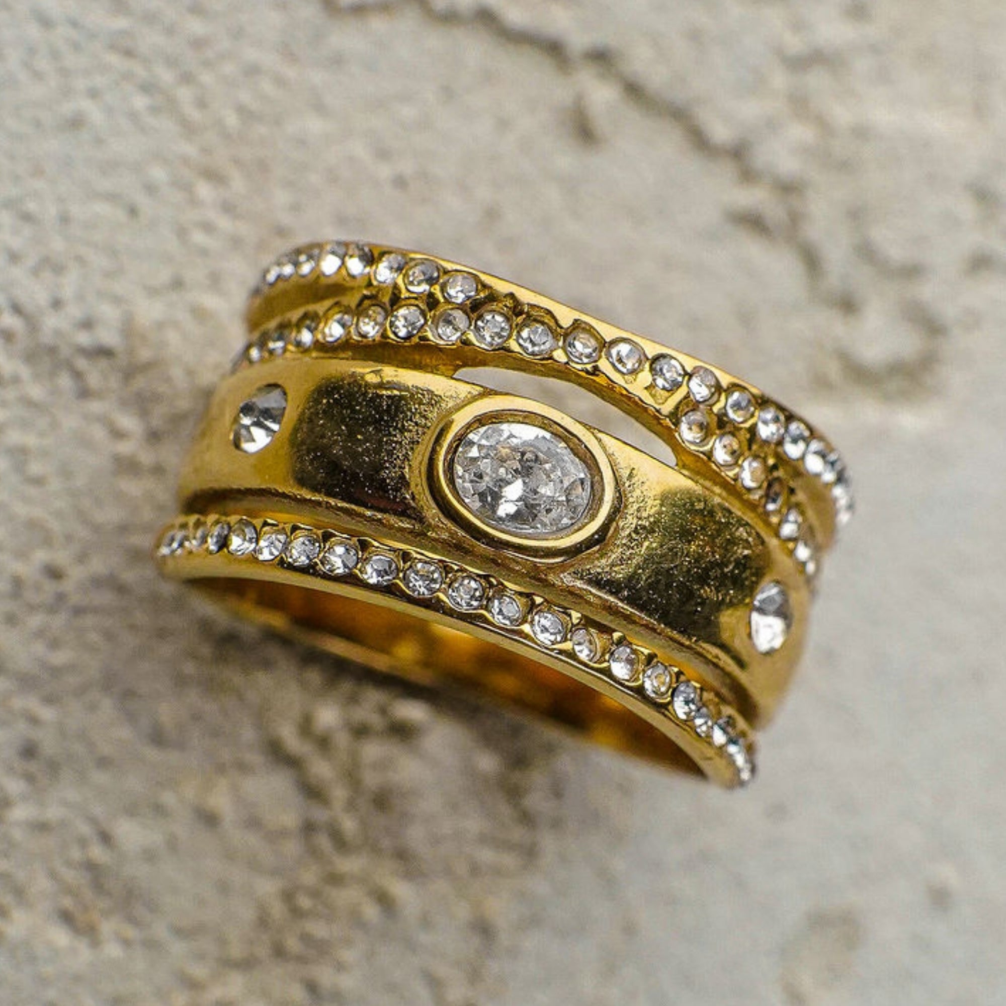 Gold ring with embedded diamonds on a textured surface