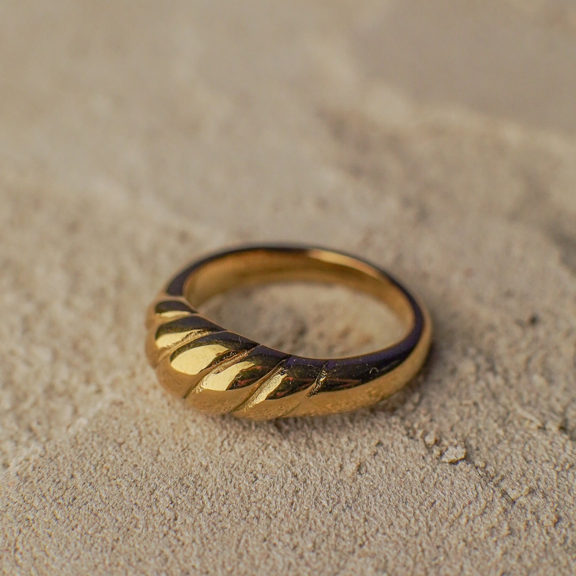 Gold ring on a sandy surface
