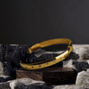 Gold headband with decorative elements on a dark stone surface