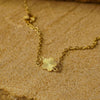 Gold necklace with a sunflower pendant on a textured brown surface