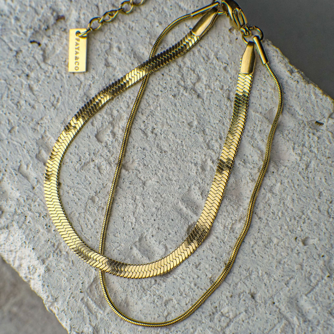 Gold necklace on a textured stone surface