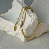 Gold necklace on a textured stone surface