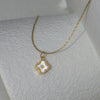 Gold necklace with a clover-shaped pendant on a mannequin bust.