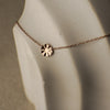 Rose gold necklace with a round pendant on a mannequin bust.