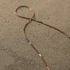 Thin brown wire on a textured beige surface