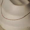 Gold necklace on a mannequin bust against a neutral background