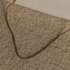 Gold chain on a textured beige surface